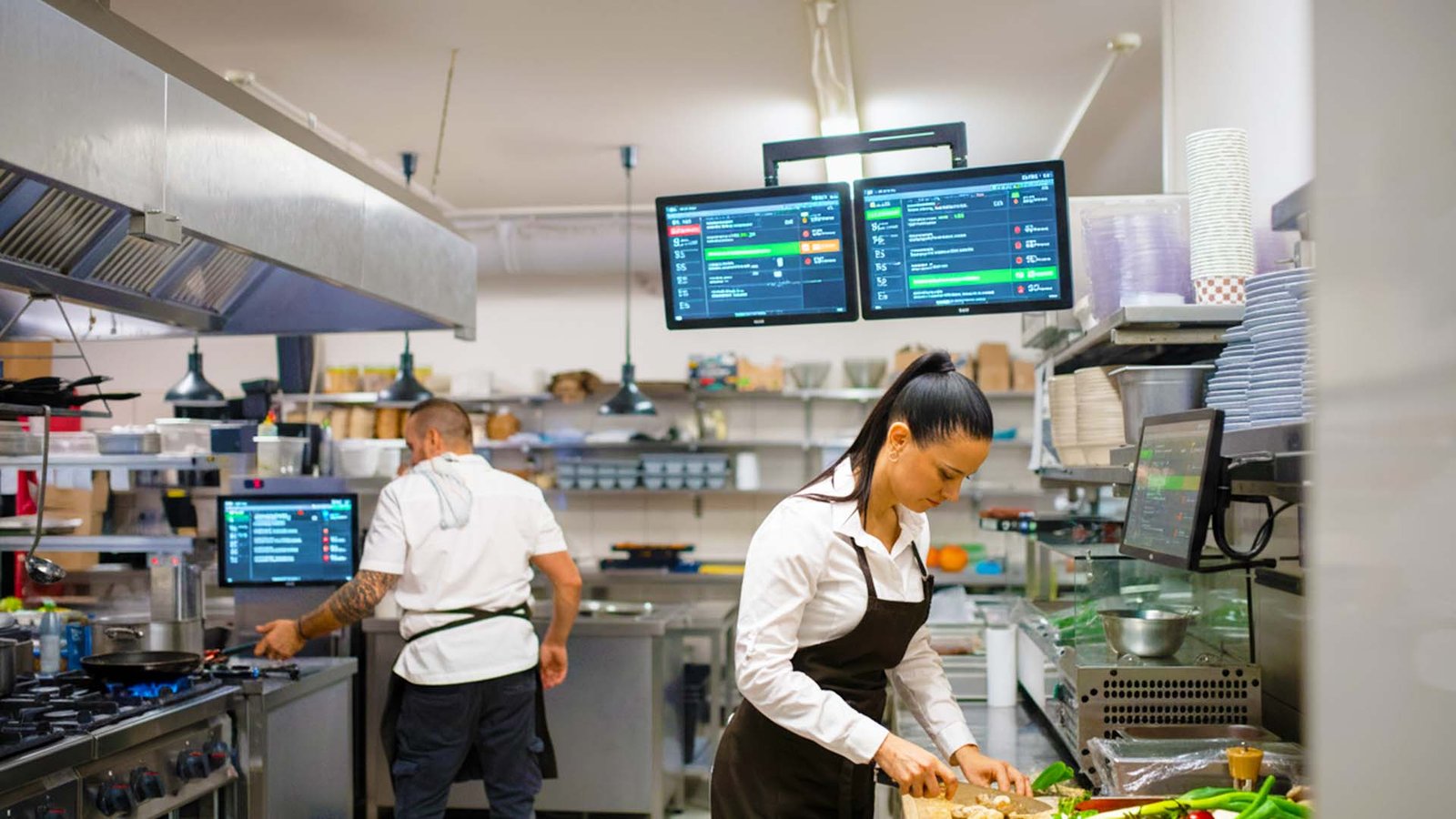 Pantallas KDS en cocina con tickets por estación